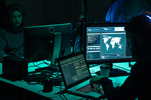 Wanted hackers coding virus ransomware using laptops and computers. Cyber attack, system breaking and malware concept